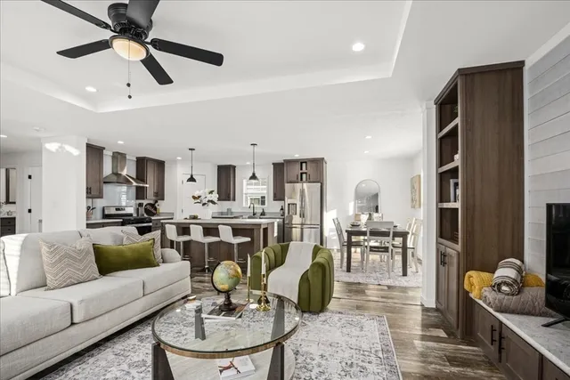 a living room with furniture kitchen view and a chandelier