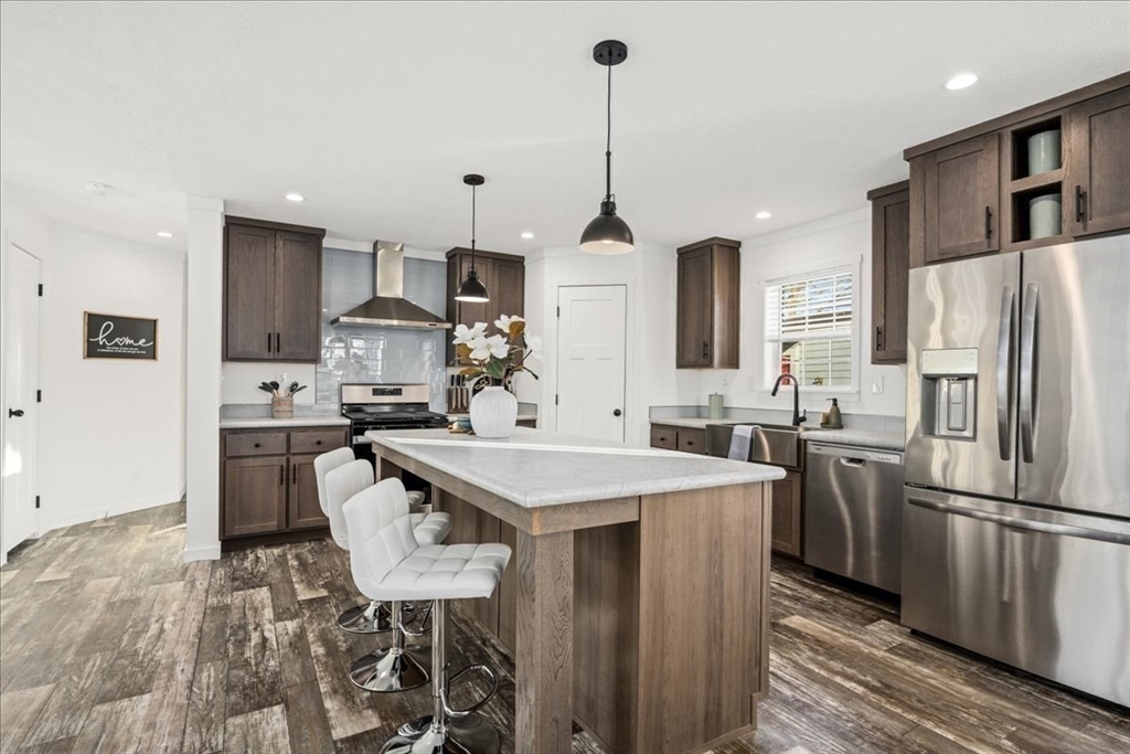 6 Berry Farms Road, Unit 64 Sturbridge, MA 01566 - Photo 8 of 18 a kitchen with stainless steel appliances a stove a sink a refrigerator a center island and chairs