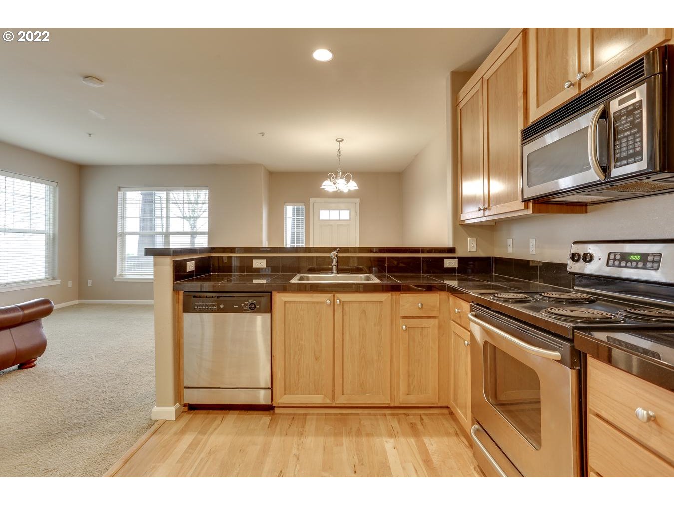 1020 Southwest 170th Avenue, Unit 100 Beaverton, OR 97003 - Photo 12 of 28 a kitchen with stainless steel appliances granite countertop a stove a sink and a microwave