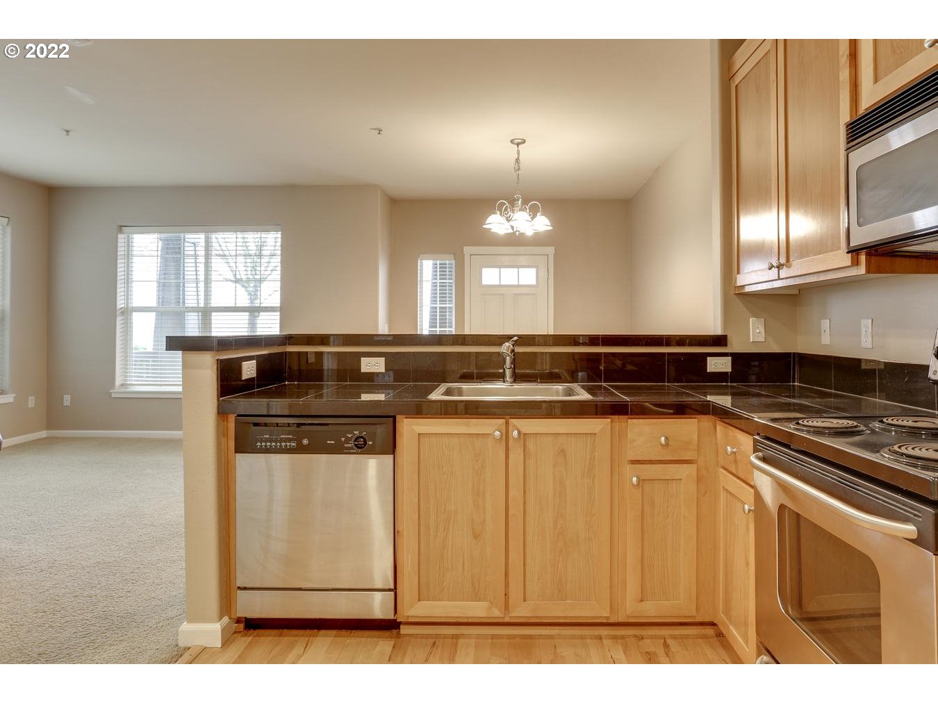 1020 Southwest 170th Avenue, Unit 100 Beaverton, OR 97003 - Photo 13 of 28 a kitchen with stainless steel appliances granite countertop a stove a sink and a microwave