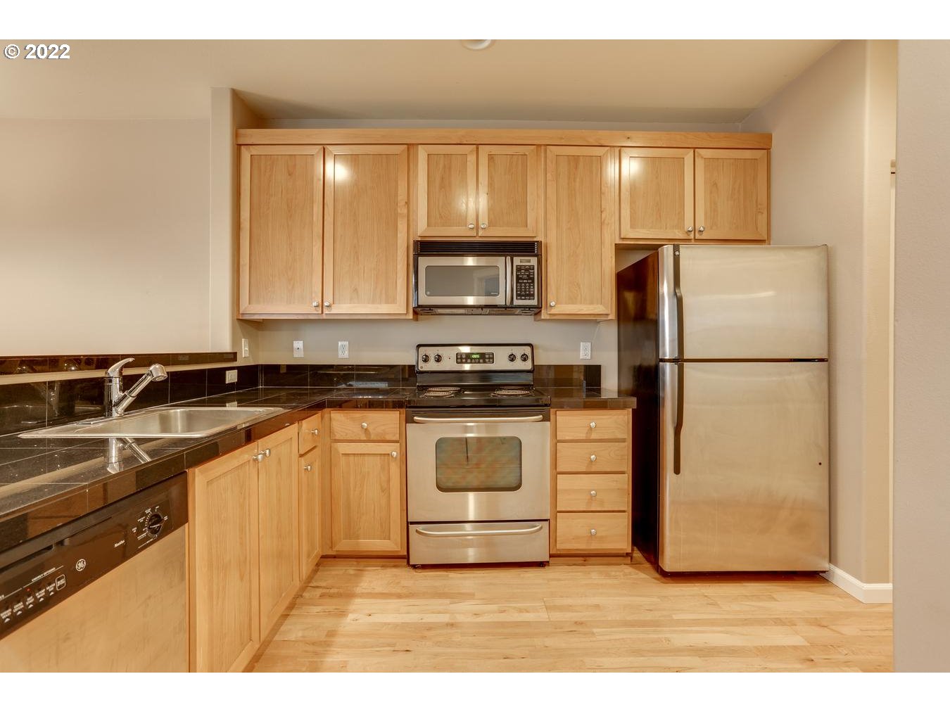 1020 Southwest 170th Avenue, Unit 100 Beaverton, OR 97003 - Photo 15 of 28 a kitchen with a refrigerator a stove top oven and cabinets