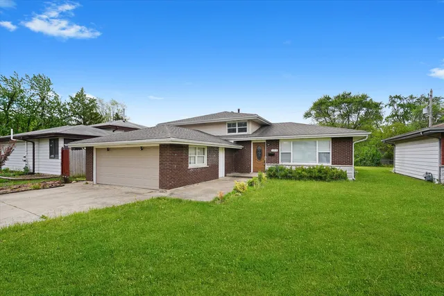 a front view of a house with a garden and yard