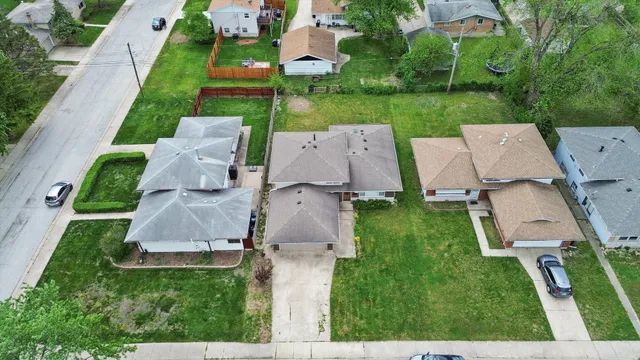 an aerial view of a house with garden space and street view
