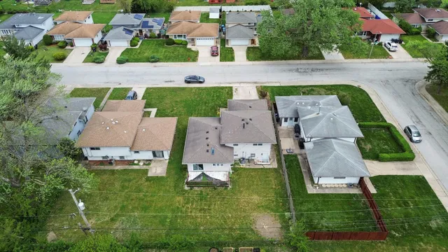 an aerial view of residential houses with outdoor space and street view