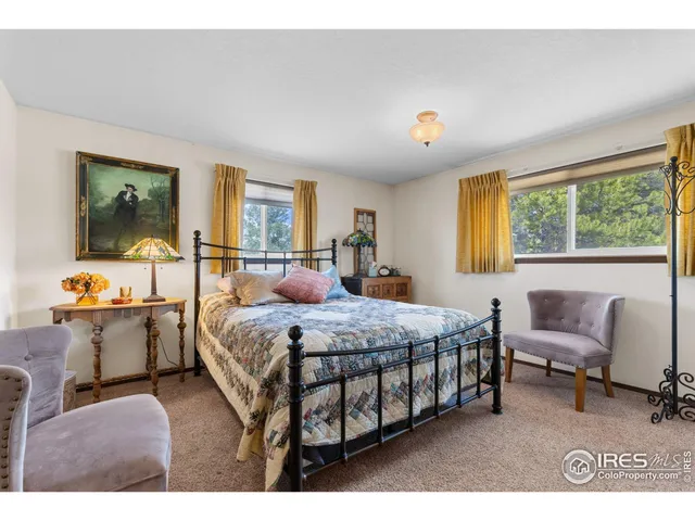 a bedroom with a bed and large windows