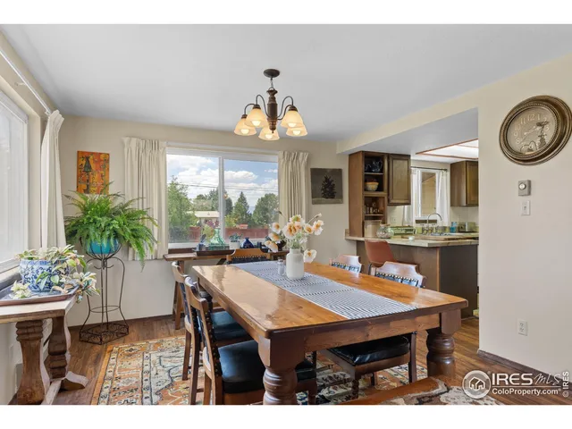 a dining room with wooden floor and a chandelier