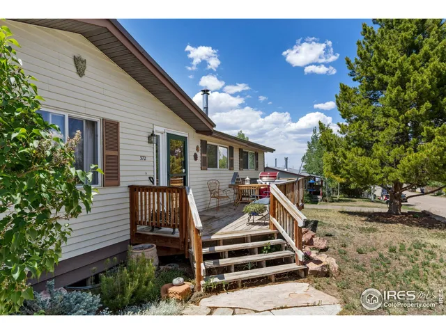 a view of a house with backyard and trees