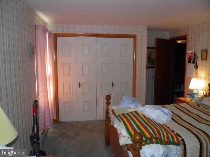 166 Bennett Berkeley Springs Berkeley Springs, WV 25411 - Photo 13 of 27 a bedroom with a bed and a chandelier
