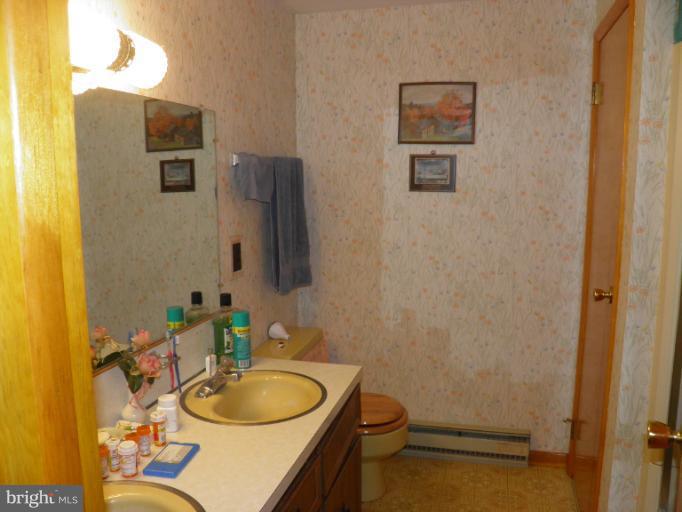 166 Bennett Berkeley Springs Berkeley Springs, WV 25411 - Photo 16 of 27 a bathroom with a granite countertop toilet sink and mirror