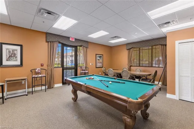 a room with furniture pool table and windows