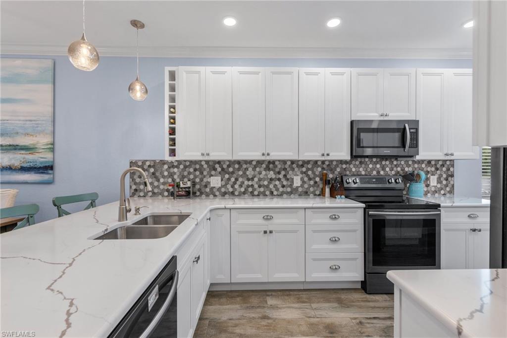 8550 Kingbird Loop, Unit 620 Estero, FL 33967 - Photo 3 of 30 a kitchen with stainless steel appliances granite countertop a sink stove and cabinets