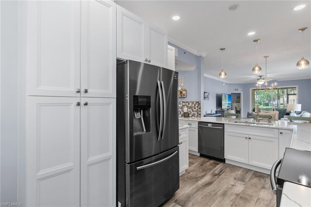 8550 Kingbird Loop, Unit 620 Estero, FL 33967 - Photo 4 of 30 a kitchen with a refrigerator a sink and cabinets