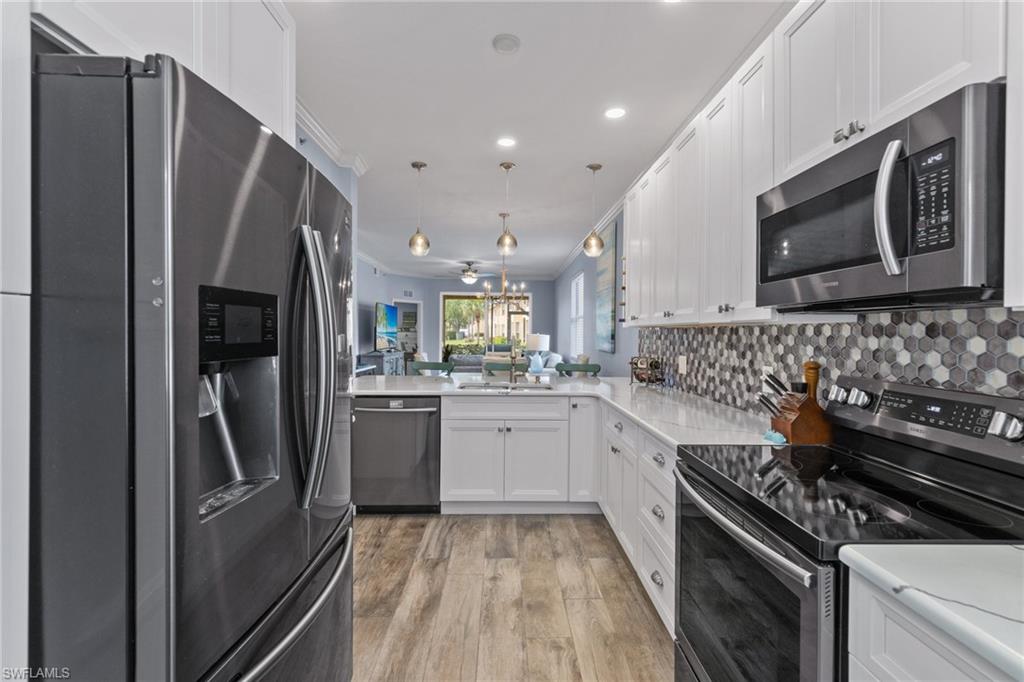 8550 Kingbird Loop, Unit 620 Estero, FL 33967 - Photo 5 of 30 a kitchen with stainless steel appliances a refrigerator a sink a stove top oven and white cabinets
