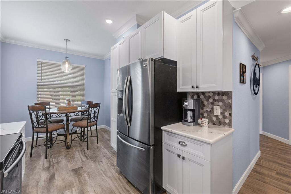 8550 Kingbird Loop, Unit 620 Estero, FL 33967 - Photo 7 of 30 a kitchen with refrigerator cabinets dining table and chairs