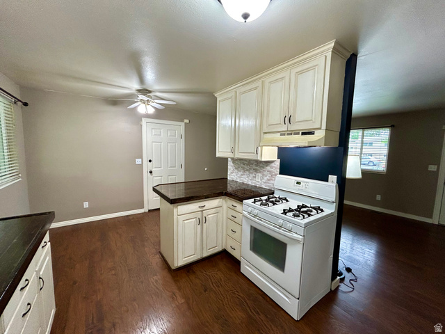 441 South 400 East Payson, UT 84651 - Photo 12 of 39 Kitchen featuring cream-colored cabinetry, dark countertops, and a white gas range