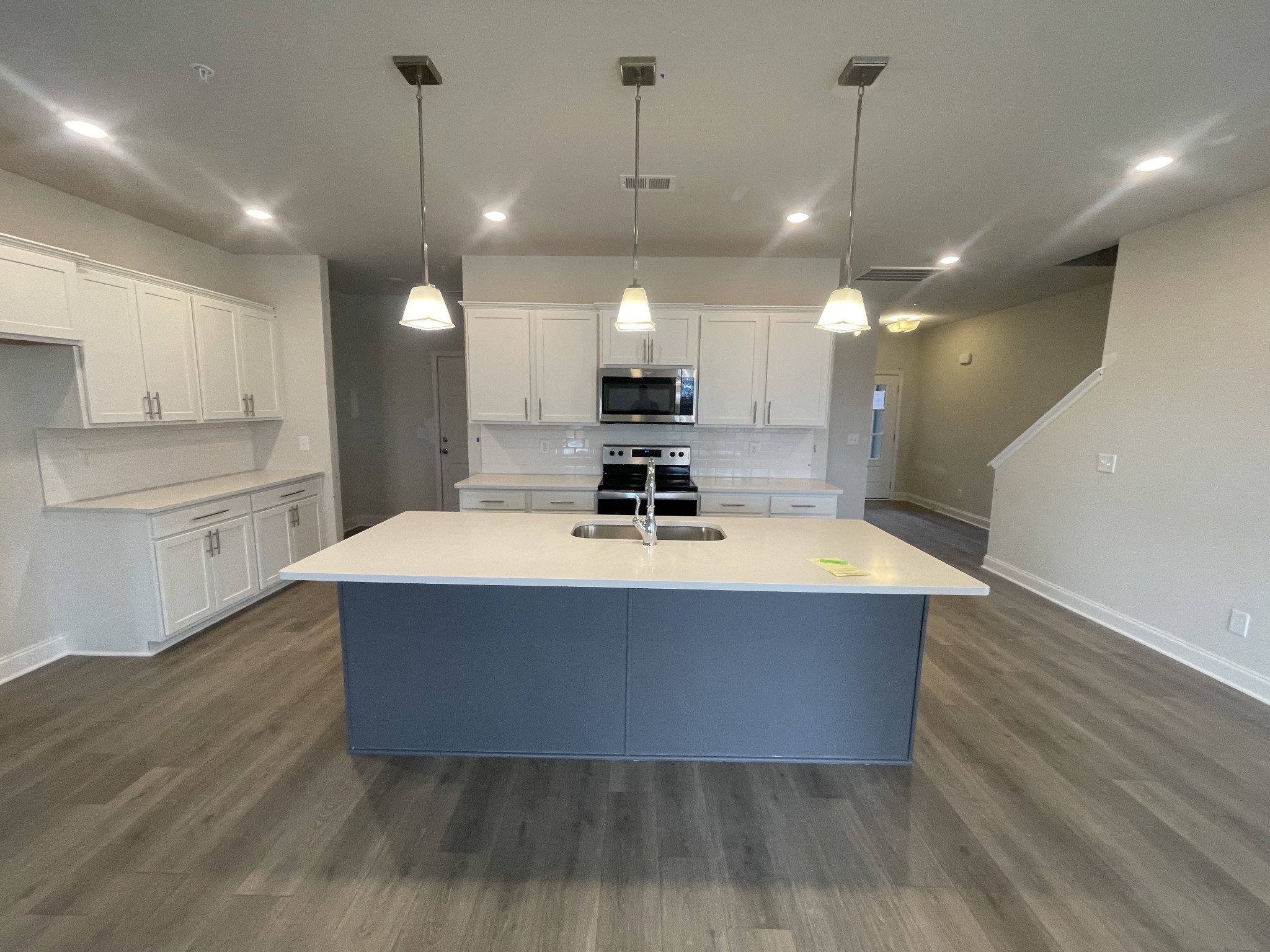 1164 June Wilde Ridge Spring Hill, TN 37174 - Photo 3 of 13 a room with kitchen island a sink wooden floor and glass door