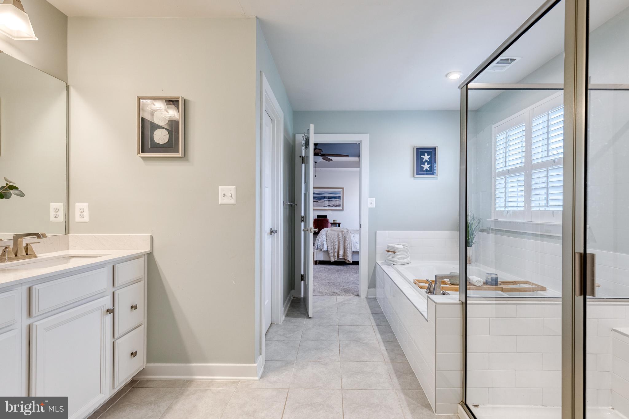 6003 Valentine Way Hanover, MD 21076 - Photo 36 of 52 a spacious bathroom with a double vanity sink a mirror and a shower