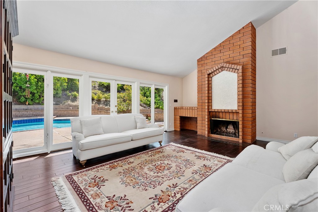 21732 Exton Way Lake Forest, CA 92630 - Photo 11 of 29 Sunken living room with firepalce, vaulted ceilings, crown molding, floor to ceiling windows that open and French doors leading to the back yard pool.