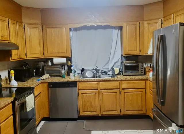 a kitchen with granite countertop a sink stainless steel appliances and cabinets