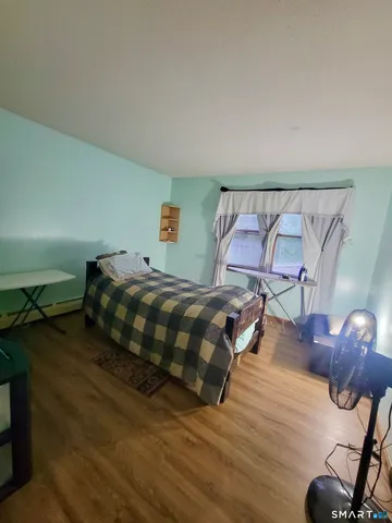 a bedroom with a bed and wooden floor