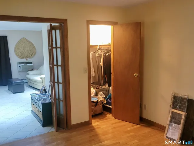 a view of a hallway with bathroom and wooden floor