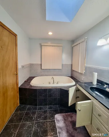 a bathroom with a tub a sink and a shower