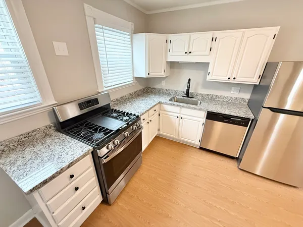 a kitchen with granite countertop a sink stove and refrigerator