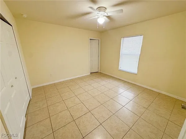 a view of an empty room and chandelier fan