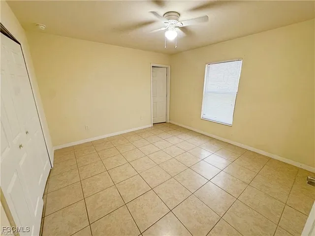 a view of an empty room and chandelier fan