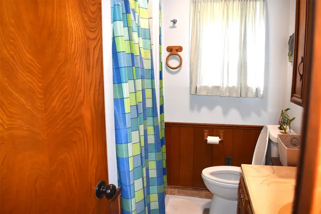 a bathroom with a sink a toilet and a window
