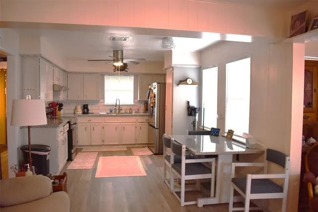 a large kitchen with stainless steel appliances granite countertop a stove and a refrigerator