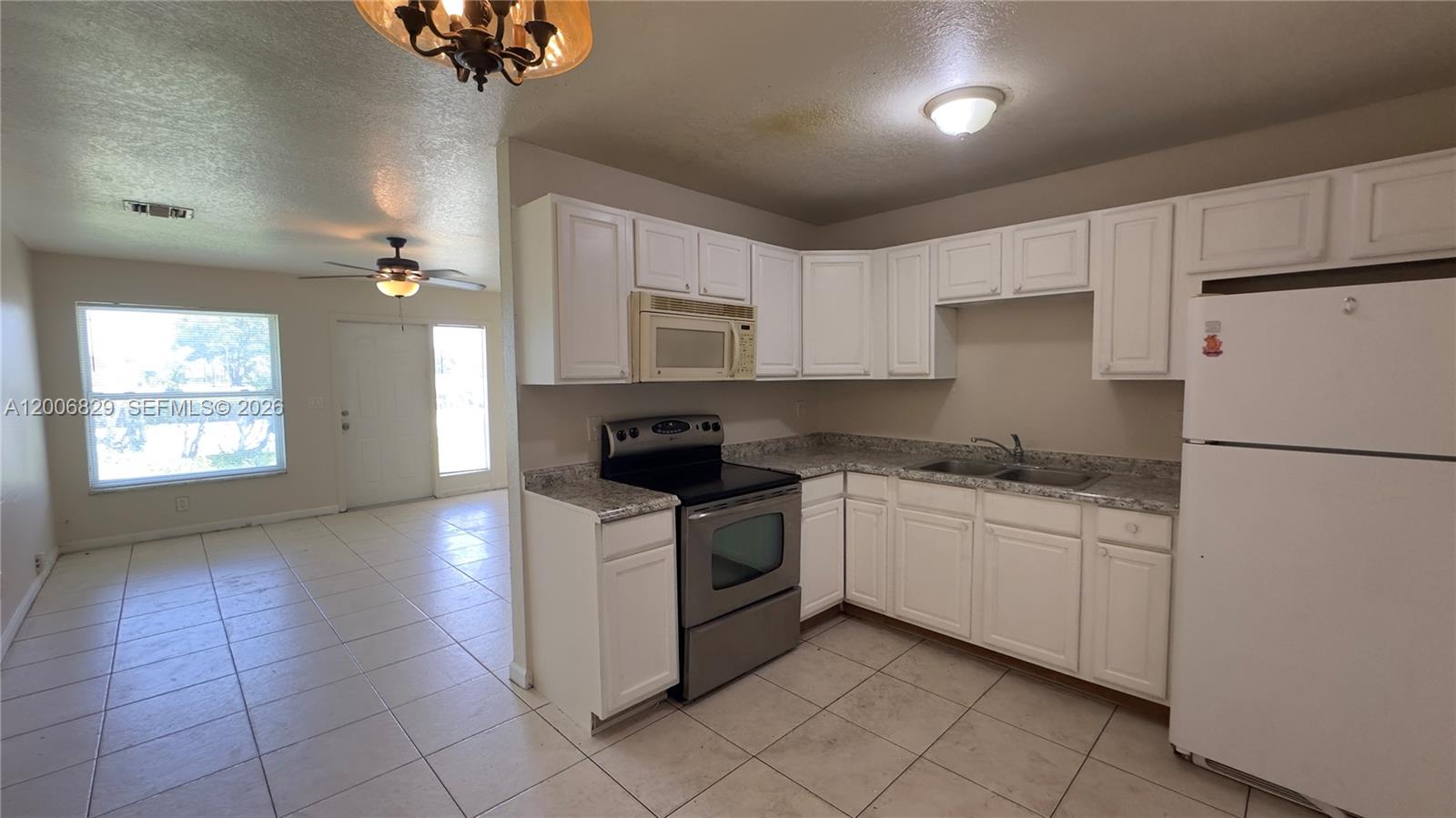 3733 Kirk Road Lake Worth, FL 33461 - Photo 11 of 24 a kitchen with granite countertop white cabinets and white appliances
