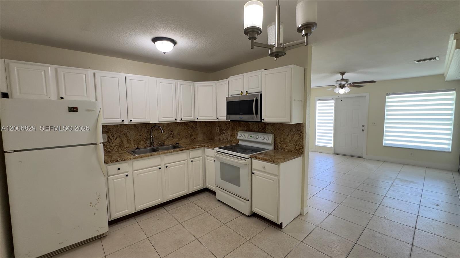3733 Kirk Road Lake Worth, FL 33461 - Photo 5 of 24 a kitchen with granite countertop white cabinets and white appliances