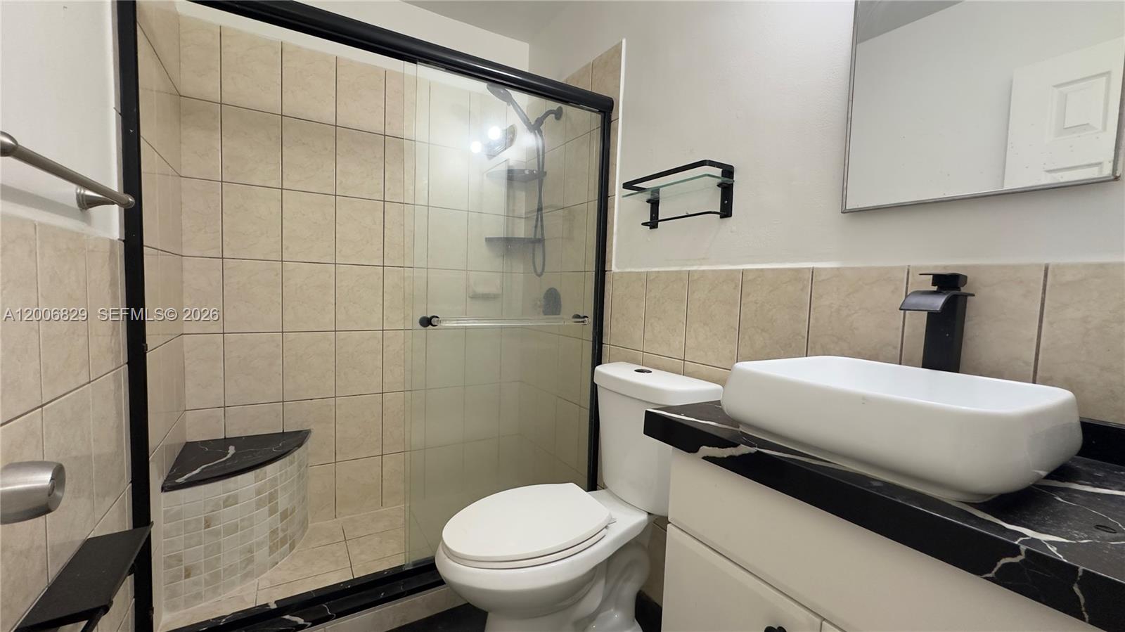3733 Kirk Road Lake Worth, FL 33461 - Photo 6 of 24 a bathroom with a toilet a sink and mirror