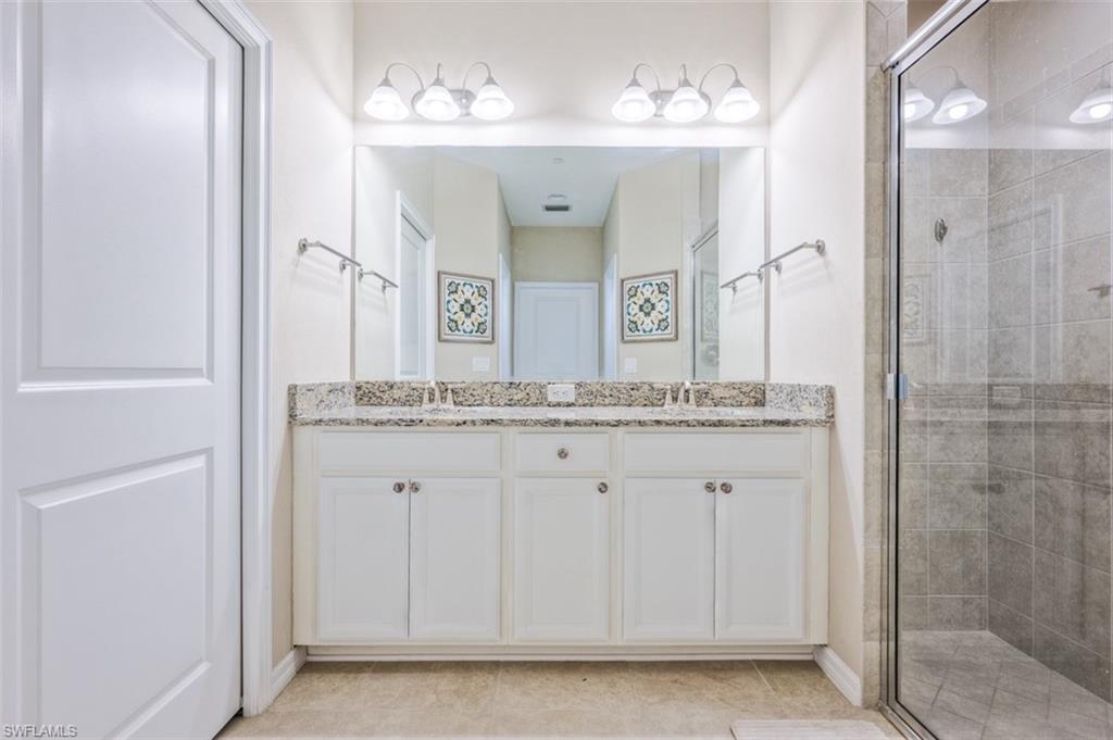9374 Pocida Court, Unit 102 Naples, FL 34119 - Photo 11 of 21 a bathroom with a sink and a mirror