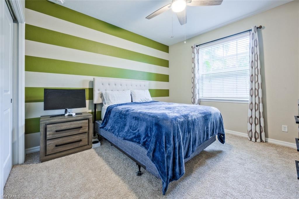 9374 Pocida Court, Unit 102 Naples, FL 34119 - Photo 13 of 21 a bedroom with a bed and a flat screen tv