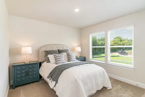 a bedroom with a bed and a large window