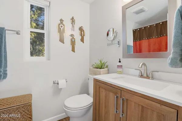a bathroom with a granite countertop sink mirror vanity and toilet