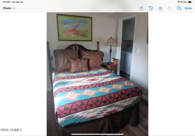 a bedroom with a bed and a painting on the wall