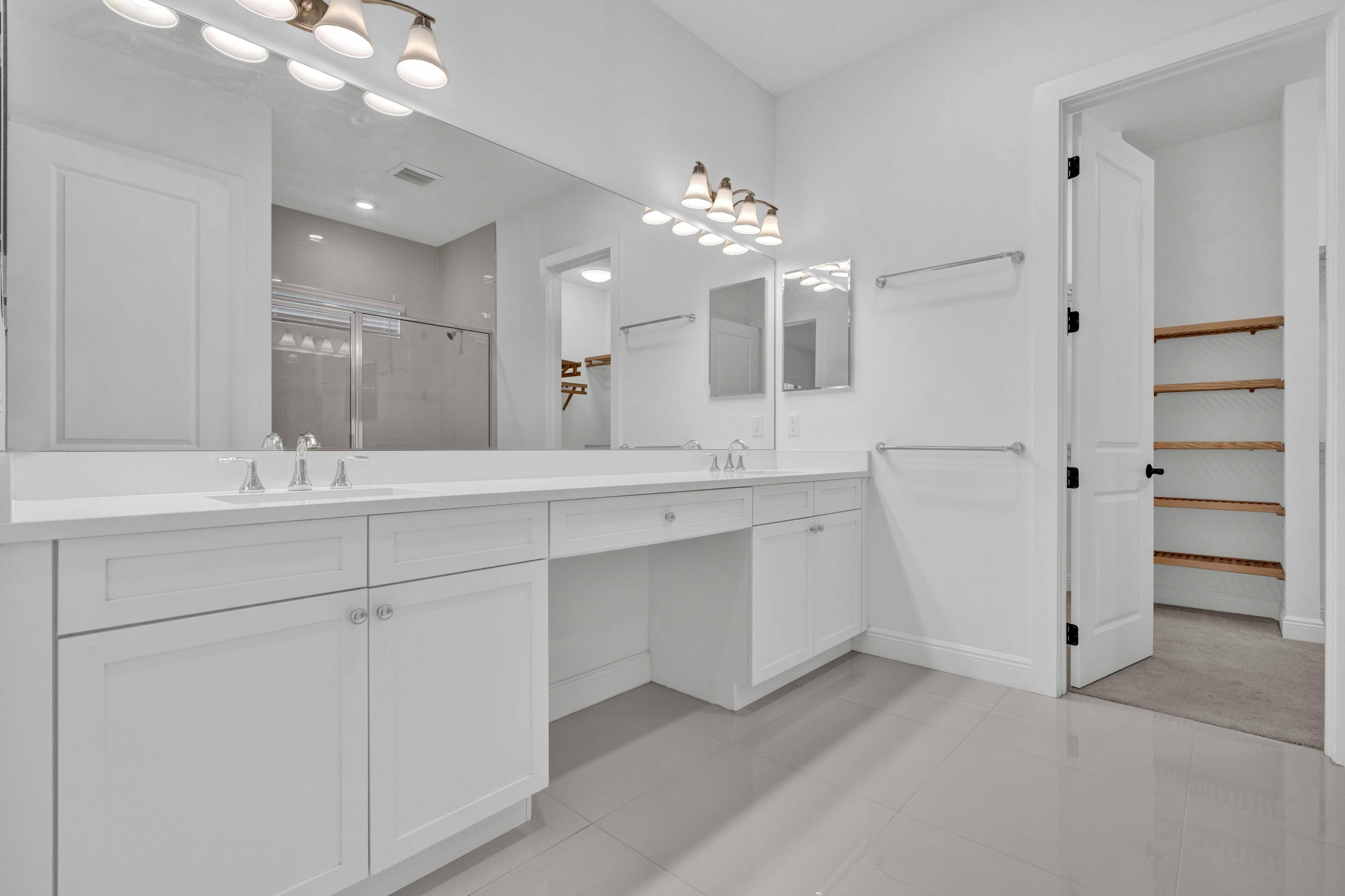 5501 Santa Rosa Lane Westlake, FL 33470 - Photo 19 of 31 a bathroom with a double vanity sink and a mirror