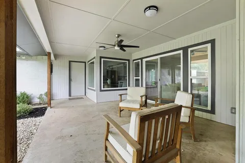 a view of a livingroom with furniture wooden floor and a ceiling fan