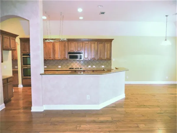 a view of kitchen with stainless steel appliances granite countertop sink