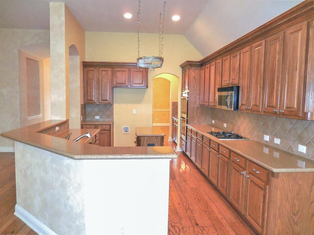 4012 Appleton Lane Flower Mound, TX 75022 - Photo 8 of 28 a kitchen with kitchen island granite countertop a sink a counter top space and cabinets