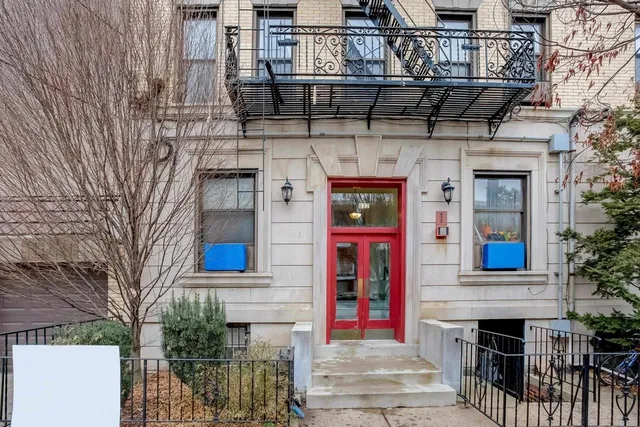 a front view of a building with red door