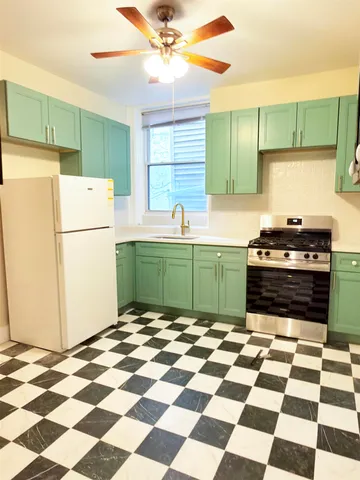 a kitchen with a refrigerator a stove and a sink