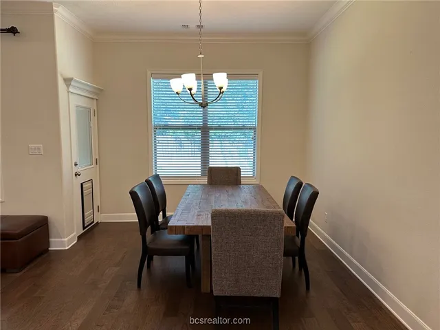a view of a dining room with furniture a chandelier and wooden floor
