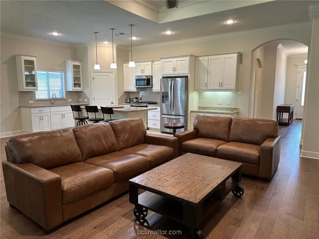 a living room with furniture kitchen and a table