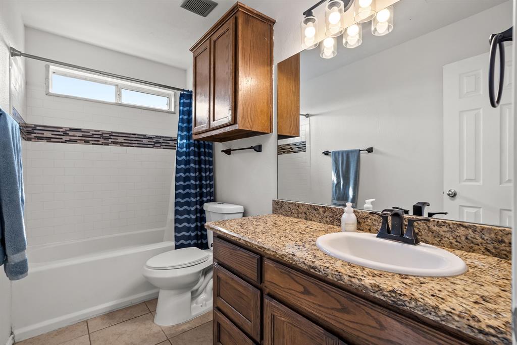 115 Blue Castle Court Weatherford, TX 76088 - Photo 20 of 33 a bathroom with a granite countertop sink a toilet and bathtub