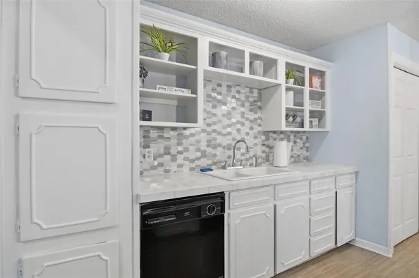 a kitchen with stainless steel appliances granite countertop white cabinets and a sink