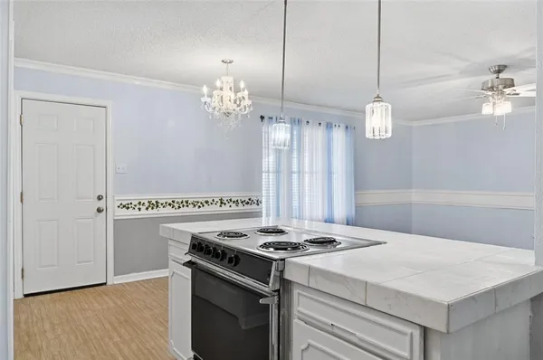 a kitchen with a stove and a chandelier